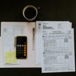 Photo of tax documents and iPhone with the calculator app open