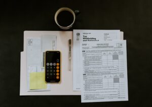 Photo of tax documents and iPhone with the calculator app open